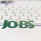 Schriftzug mit Jobs und Tastatur im Hintergrund