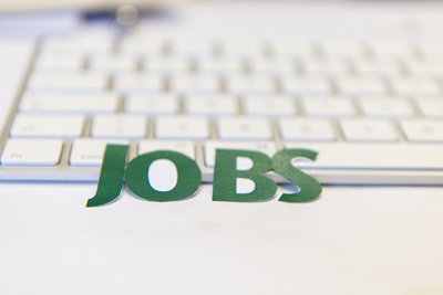 Schriftzug mit Jobs und Tastatur im Hintergrund